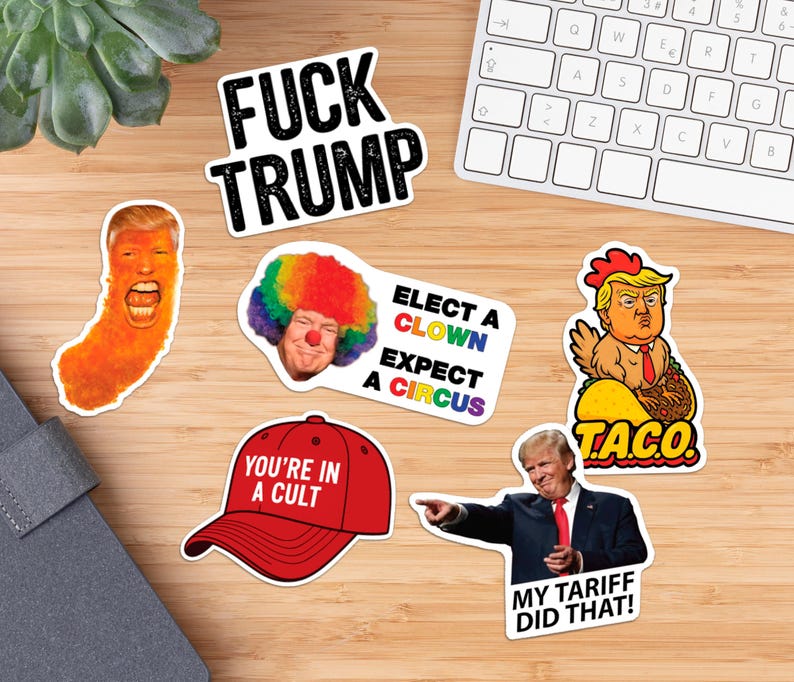 May include: A collection of political stickers with various designs and text. One sticker reads "FUCK TRUMP" in bold black letters. Other stickers include images of a clown, a taco, and a red baseball cap with the text "YOU'RE IN A CULT".