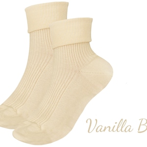 May include: Three pairs of ribbed socks in different colors: white, cream, and burgundy. The socks are folded down at the top, creating a cuffed look.