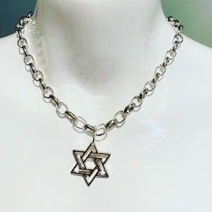 Può includere: Una collana a catena d'argento con un ciondolo a stella di David d'argento.