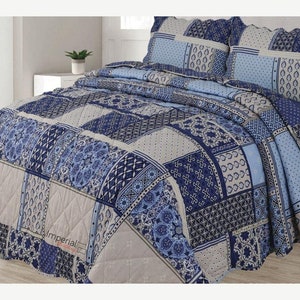May include: Blue and beige patchwork quilt set featuring a decorative pattern. The set includes a quilt and two pillowcases. The quilt has a quilted design and the pillowcases have a flat design.