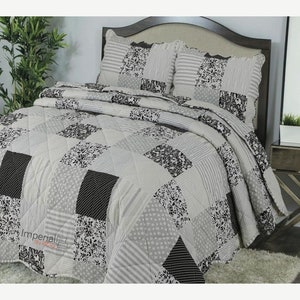 May include: A grey and black patchwork quilt set with a floral pattern. The set includes a quilt and two pillow shams.