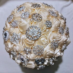 Ramo de broche de boda de marfil: exquisitas flores de satén nupcial con un toque romántico