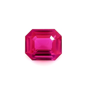 Peut inclure: Une pierre précieuse rose vif de taille émeraude. La pierre précieuse est facetée et a un haut poli.