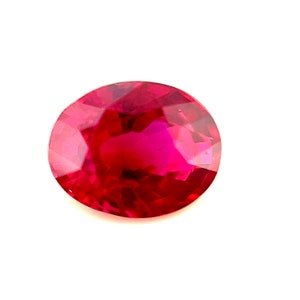 May include: A vibrant red oval-shaped gemstone with a faceted cut.