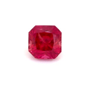 Puede incluir: Una piedra preciosa de color rojo intenso con un corte cuadrado y un acabado facetado.
