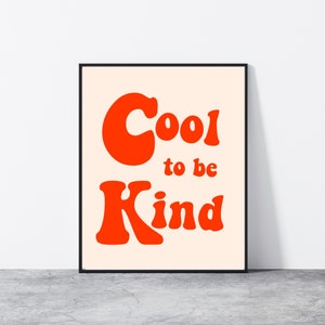 May include: A framed print with a peach background and the text "Cool to be Kind" in red, stylized lettering.