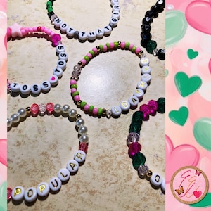 May include: Six colorful beaded bracelets with different words spelled out on them. The words are "Toss", "Not That Girl", "Loathing", "Popular", and two bracelets with the word "Toss" on them.