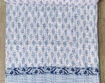May include: A white and blue kantha quilt with a floral pattern. The quilt has a blue border with a floral design.