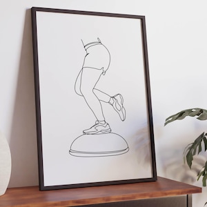 Puede incluir: Una lámina de arte mural enmarcada con un dibujo de líneas negras sobre fondo blanco. La ilustración muestra a una persona con pantalones cortos y zapatillas deportivas, haciendo equilibrio sobre una pelota de ejercicio en forma de cúpula.