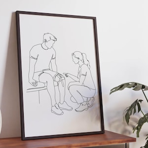 Può includere: Una stampa artistica in bianco e nero incorniciata che presenta un disegno a linea continua di un operatore sanitario inginocchiato per esaminare il ginocchio di un paziente seduto su un lettino da visita. Linee nere semplici su sfondo bianco.