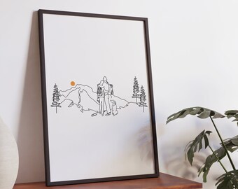 May include: A black framed print of a line drawing of a couple and a dog standing on a mountain with a sun in the background.