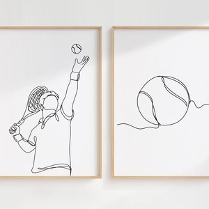 May include: Two framed art prints with tennis-themed line drawings. One shows a tennis player serving, racket in hand, with the ball airborne. The other print depicts a tennis ball. Both are in simple black lines.