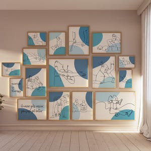 May include: A wall gallery featuring 13 framed illustrations of people in various yoga poses. The illustrations are in black and white line art with blue and teal accents. The frames are gold and the wall is a light beige color. The text "it never gets easier, you just get better" is featured on one of the frames.