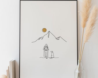 May include: A black framed print of a line drawing of a person hiking with a dog in front of a mountain with a yellow sun in the sky.