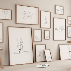 Puede incluir: Una colección de 13 impresiones de arte de línea enmarcadas que presentan varias poses y ejercicios de fitness. Las impresiones se muestran en una pared beige claro con una mesa y taburetes de madera en primer plano.