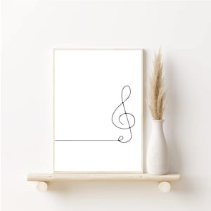 May include: A black and white line drawing of a treble clef on a white background. The drawing is framed and displayed on a shelf.