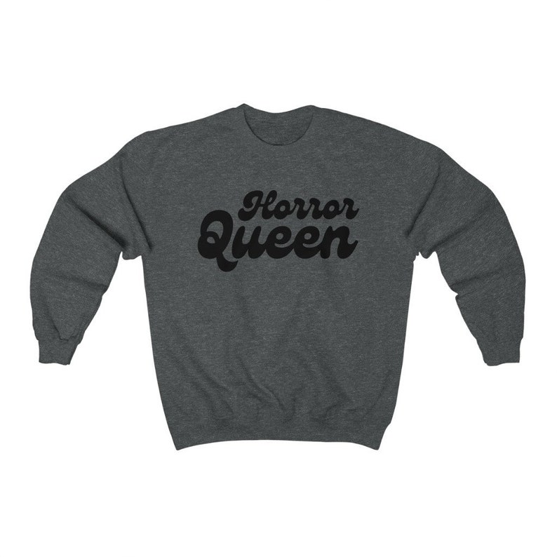 Może przedstawiać: Ciemnoszara bluza z napisem "Horror Queen" w czarnym, retro kroju czcionki. Bluza ma okrągły dekolt i długie rękawy. Tekst jest wyśrodkowany na klatce piersiowej.