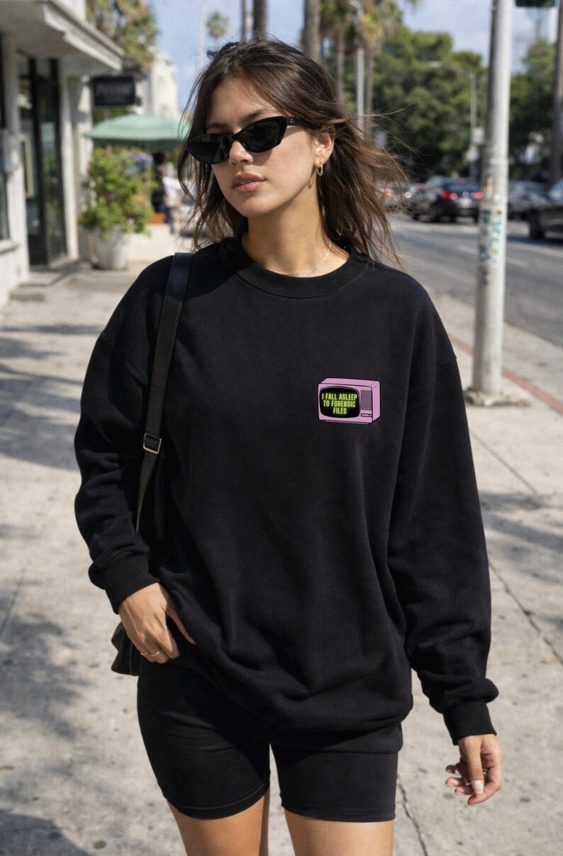 Op de afbeelding: Een witte keramische mok met een zwart handvat en de tekst "But First, Coffee" in een vetgedrukte, zwarte letter. De mok staat tegen een vage achtergrond, wat een gezellige omgeving suggereert.