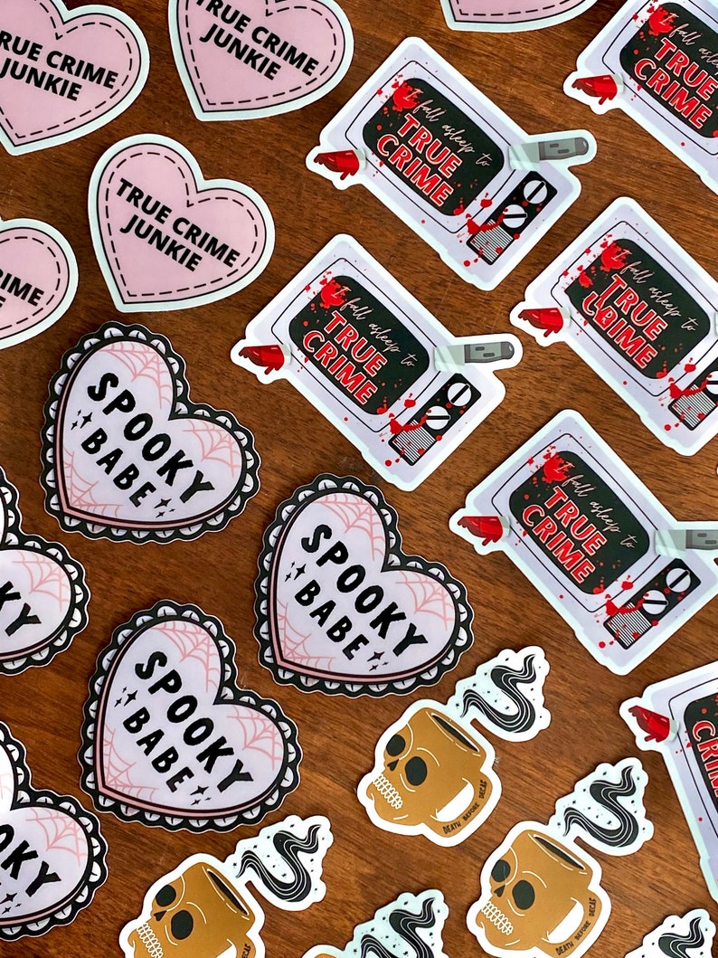 May include: Assortment of stickers featuring various designs, including hearts with the text "Spooky Babe" and "True Crime Junkie", and a television with the text "Fall Asleep to True Crime".