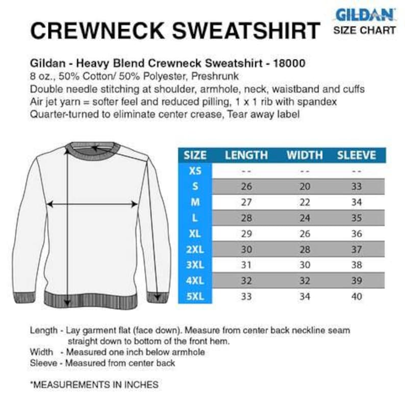 Op de afbeelding: Een witte crewneck sweatshirt met een maattabel. De tabel toont afmetingen in inches voor maten XS tot 5XL. De sweatshirt is gemaakt van een katoen- en polyestermix en heeft dubbele stiksels.
