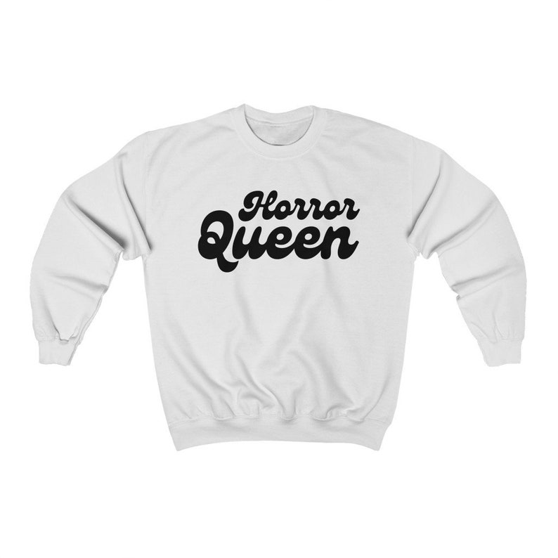 Może przedstawiać: Biała bluza z czarnym napisem "Horror Queen" w retro czcionce.