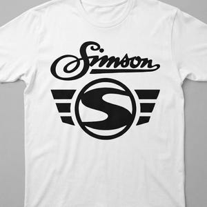 Könnte beinhalten: Ein weißes T-Shirt mit kurzen Ärmeln und einem schwarzen Grafikdruck auf der Brust. Das Design zeigt den Schriftzug Simson in einer geschwungenen Schreibschrift über einem kreisförmigen Emblem mit einem großen S und drei Balken.