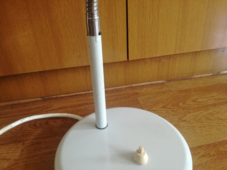 May include: White metal floor lamp with a white cord and a white on/off switch on the base.