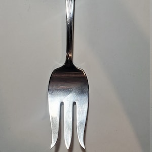 May include: A silver fork with a decorative handle and three tines.