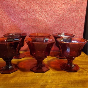 May include: Set of six red glass dessert dishes with a faceted design. The dishes have a pedestal base and are perfect for serving ice cream, pudding, or other desserts.