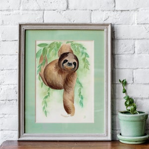 May include: A watercolour painting of a brown sloth hanging from a green tree branch. The sloth is smiling and has a light brown fur coat. The background is a light green watercolour wash.