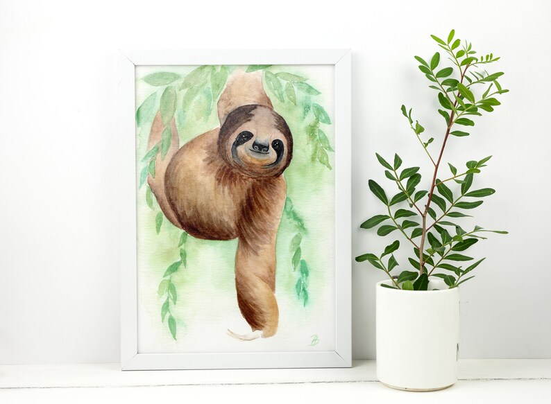 May include: A watercolour painting of a brown sloth hanging from a branch with green leaves. The sloth is looking at the viewer with a friendly expression.