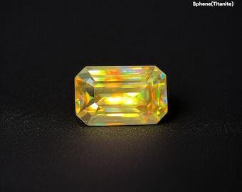May include: A lime yellow emerald-cut gemstone, 2.13 ct Sphene (Titanite), is displayed against a black background. The gem has a rectangular shape with faceted edges, showcasing a vibrant, iridescent play of colors within its structure.