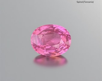 May include: A faceted, oval-shaped bubble gum pink spinel gemstone from Tanzania. The gem weighs 8.04 ct and is displayed on a reflective surface. The image includes the text "Bubble Gum Pink 8.04 ct Spinel(Tanzania)".