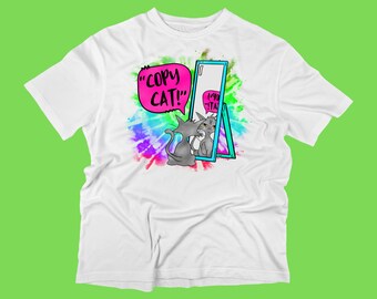 Może przedstawiać: Biała koszulka z wzorem tie-dye i kreskówkowym kotem patrzącym w lustro. Kot mówi "copy cat!" w dymku.