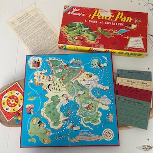 May include: A vintage Walt Disney's Peter Pan board game. The red box features illustrations of Peter Pan and Neverland. The game includes a colourful map of Neverland, character cards, instructions, and a spinner. A classic family game.