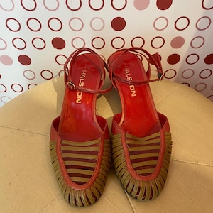 May include: A pair of red leather heeled sandals with a woven brown leather design. The sandals have ankle straps and the brand name "HALSON" is printed on the inside of each sandal.