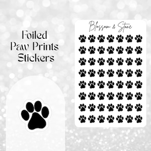 May include: Black paw print stickers on a white background, with the text "Foiled Paw Prints Stickers" and the brand name "Blossom & Stone". The stickers are arranged in a grid pattern. Ideal for crafts.
