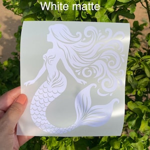 K&ouml;nnte beinhalten: Wei&szlig; matte Aufkleber mit einer Meerjungfrau-Silhouette mit flie&szlig;endem Haar und einem detaillierten Schwanz. Das Meerjungfrau-Design ist hellwei&szlig; und undurchsichtig. Der Text "White matte" ist oben auf dem Aufkleber aufgedruckt.