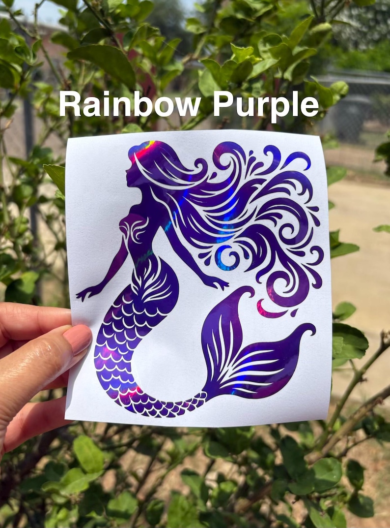 K&ouml;nnte beinhalten: Ein violetter Meerjungfrau-Aufkleber mit schillernden Highlights. Der Aufkleber zeigt eine Meerjungfrau-Silhouette mit flie&szlig;endem Haar und einem detaillierten Schwanz. Der Text "Rainbow Purple" wird &uuml;ber dem Aufkleber angezeigt.