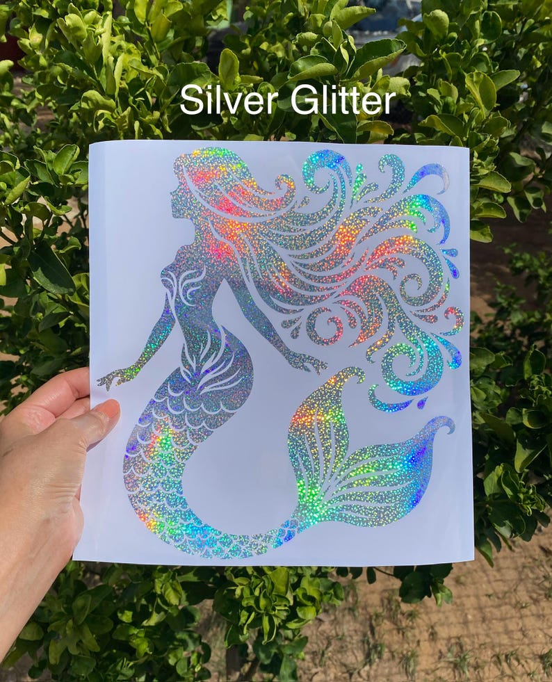 K&ouml;nnte beinhalten: Holografischer Meerjungfrau-Aufkleber mit silbernem Glitzer. Die Meerjungfrau hat flie&szlig;endes Haar und einen detaillierten Schwanz mit Regenbogenakzenten. Der Text "Silver Glitter" steht oben.