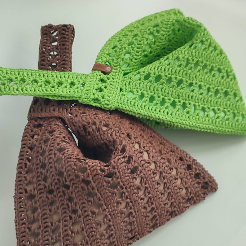 a crocheted bag with a green bow on top of it