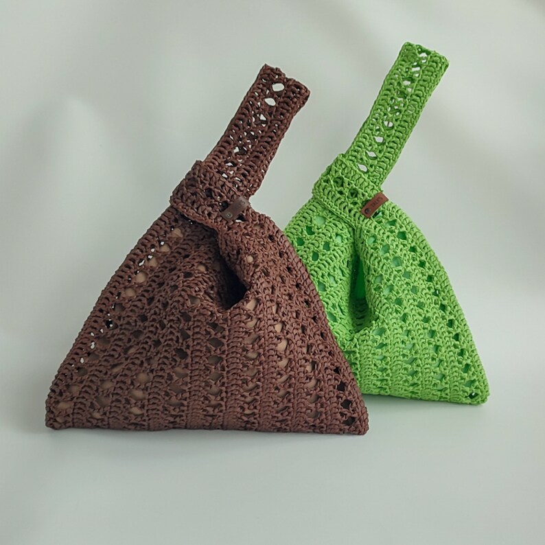 two crocheted purses sitting side by side on a white surface