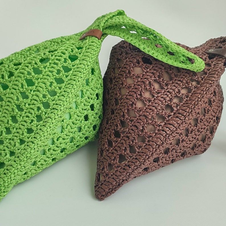 two crocheted bags sitting next to each other