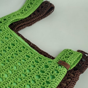 a crocheted green and brown bag sitting on top of a table