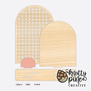 Peut inclure: Un organiseur de bureau en bois avec un fini grain de bois clair. La conception comprend un dessus arqué avec un motif tissé, une pièce arquée pleine et une base rectangulaire. Le texte "Knotty Pines Creative" et les réseaux sociaux sont visibles.