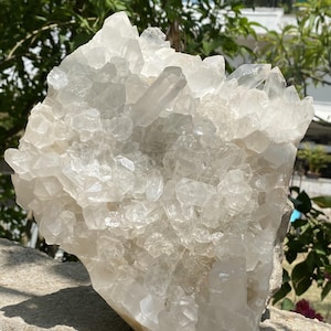 Könnte beinhalten: Eine große Ansammlung von klaren, durchscheinenden Quarzkristallen mit scharfen, facettierten Spitzen und gezackten Kanten. Die Mineralformation weist eine dichte Anordnung von Kristallstrukturen unterschiedlicher Größe und Form auf, die ein helles, reflektierendes weißes und transparentes Erscheinungsbild zeigen.
