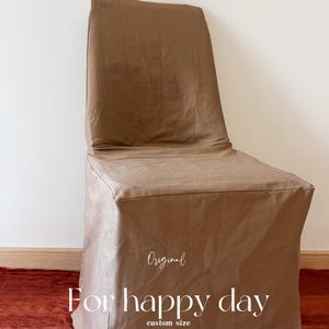 May include: A brown chair cover with a tailored fit. The cover is draped over a chair, with the text "Original" and "For happy day custom size" in a script font.