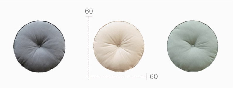 May include: Three round floor cushions, each measuring 60 cm in diameter. The cushions are made of a soft, textured fabric. One cushion is grey, one is beige, and one is green.