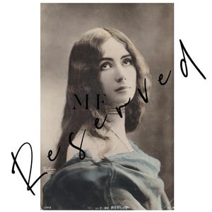 Pode incluir: Um retrato fotográfico vintage em tom sépia de uma pessoa com cabelos longos e ondulados, vestindo uma peça escura com ombros à mostra e um colar tipo gargantilha. O texto "Reserved" está sobreposto em letra cursiva preta e "Cléo de Mérode" abaixo.
