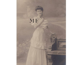 Vintage postcard, Pretty young Victorian woman posing near a bench